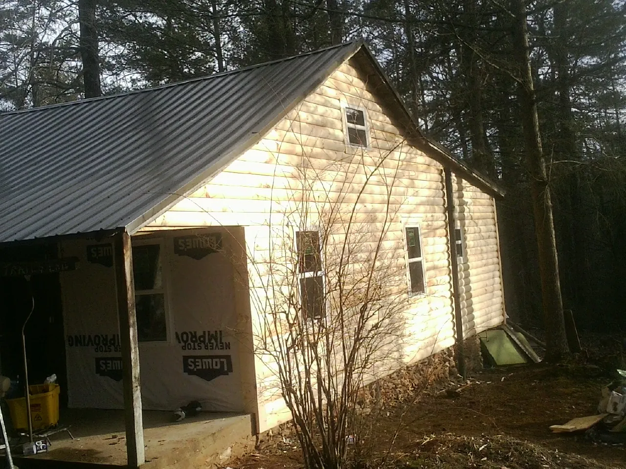 Log siding gable end under a dark metal roof edge in Cumberland City