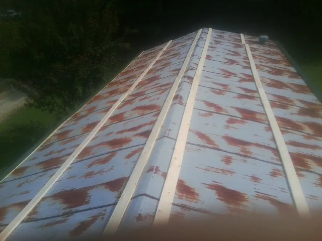 Rusted metal roof panels with new wood purlins before replacement — Storm Damage Roof Repair in Cumberland City by Roofing Brothers