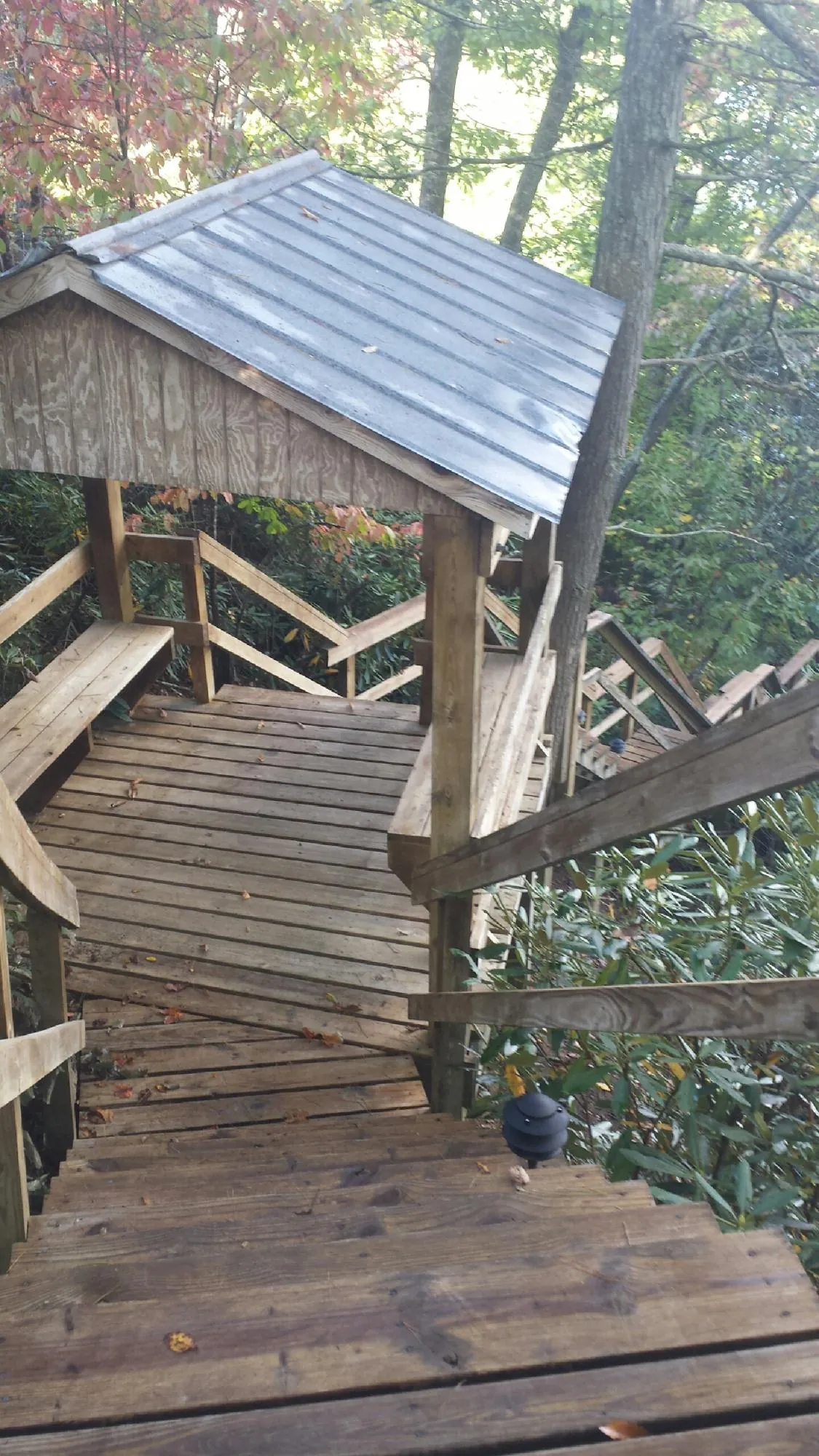 Metal roofed shelter over wooden steps on a wooded walkway — Skylight Repair & Installation work by our crew in Cumberland City